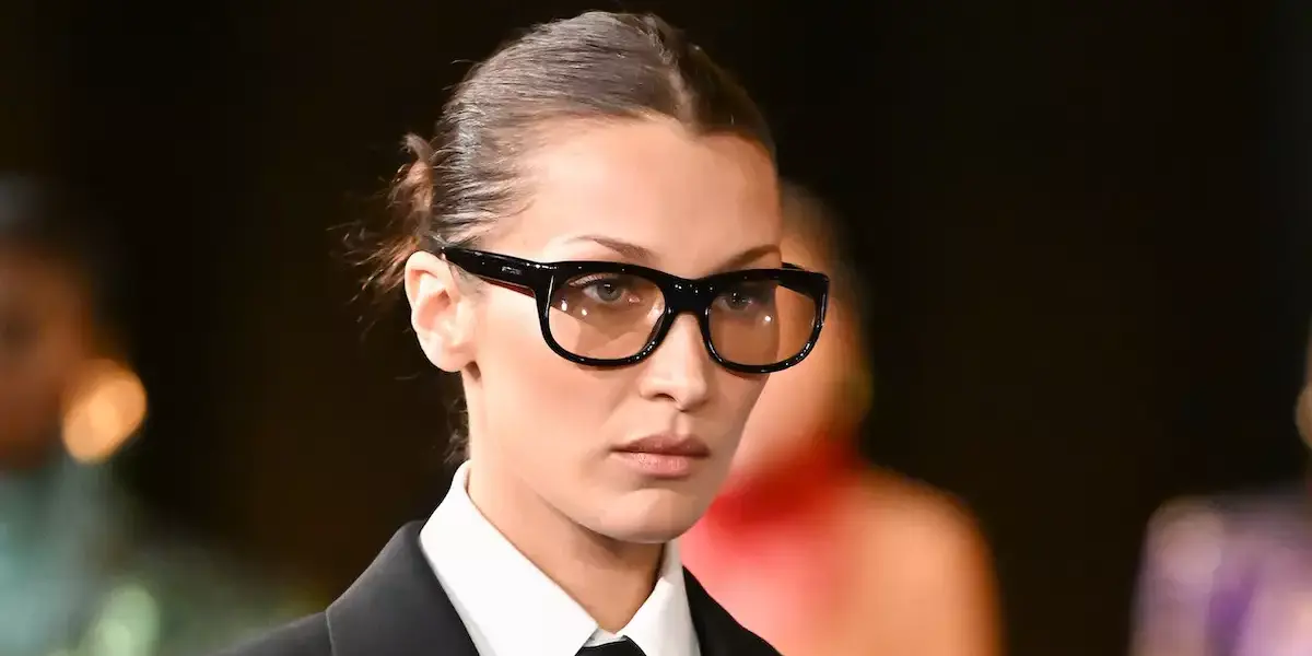 Profile close-up of a model wearing distinct hexagonal metal frames.