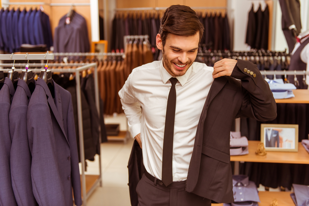 Man adjusting his jacket in a clothing store