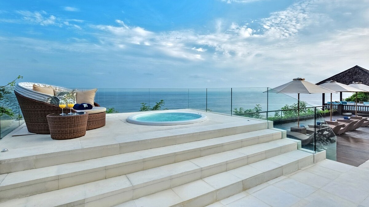 Luxury overwater bungalow deck with lounge chairs and a private plunge pool facing the sea.