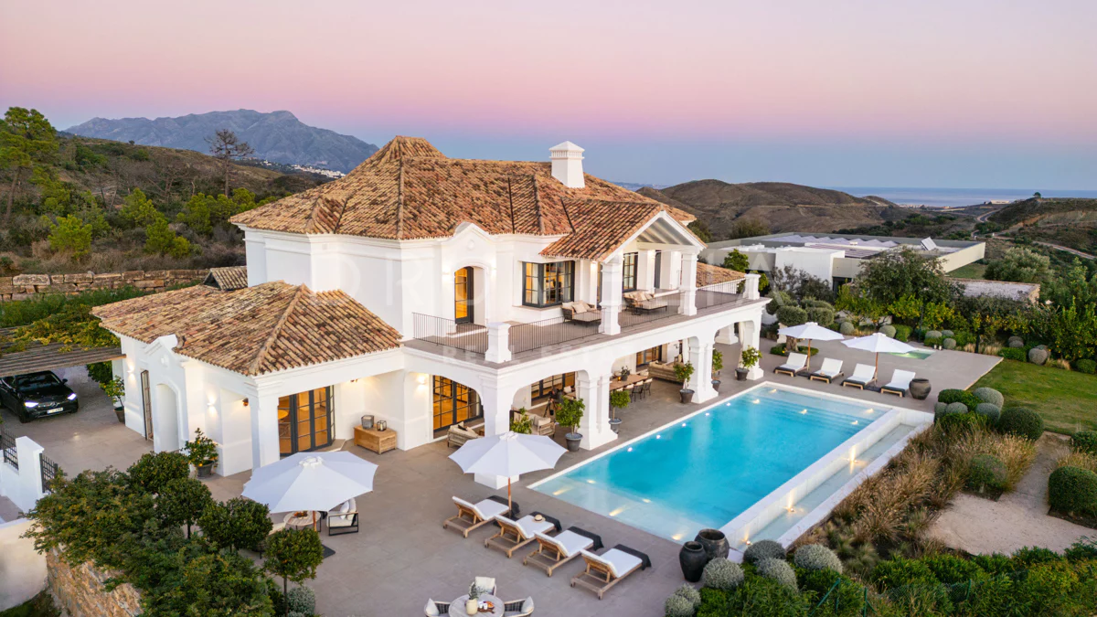 Two-story overwater luxury villas with wooden sun decks and private plunge pools extending into clear turquoise water.