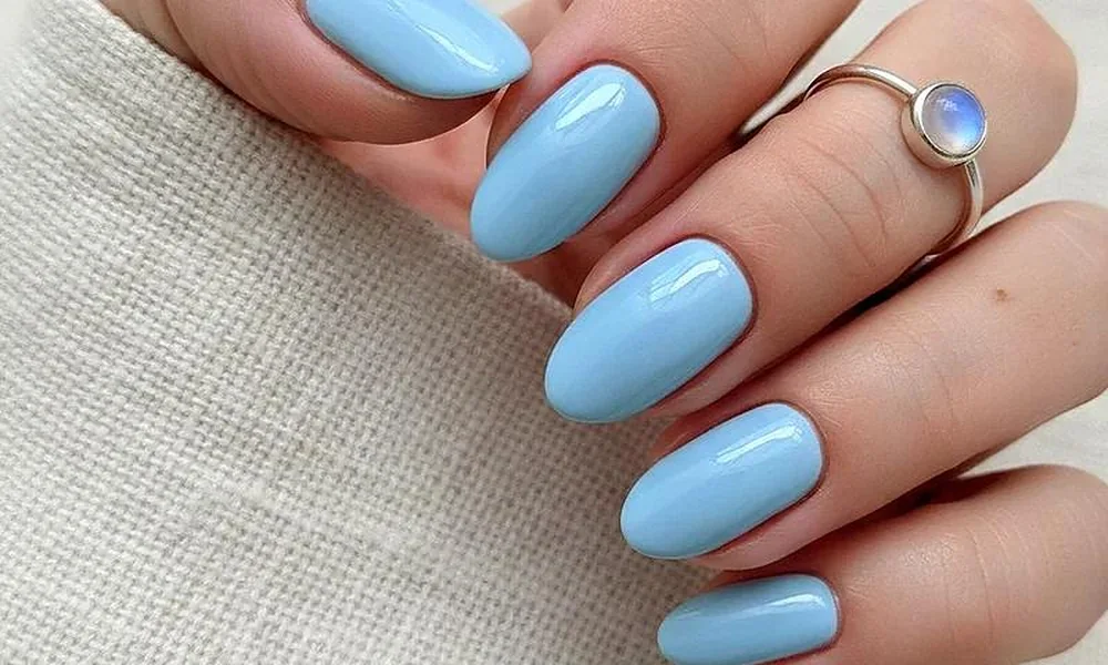 Smooth sky blue polish with a glossy finish styled on neat oval-shaped tips