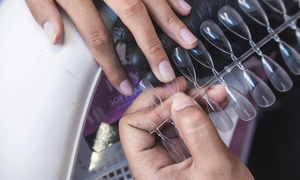 Nail technician sizing and choosing the right soft-gel tips for custom gel x nails application