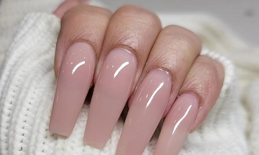 Long nude pink coffin gel x nails with tapered sides and a flat tip design