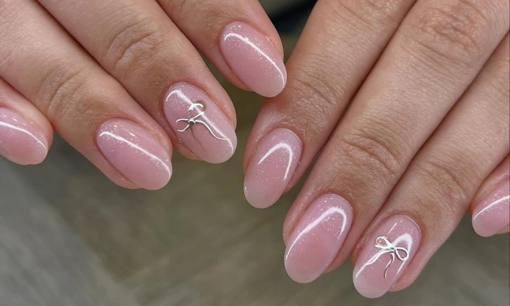 Soft sheer pink base background detailed with delicate silver ribbon bows and tiny shimmer