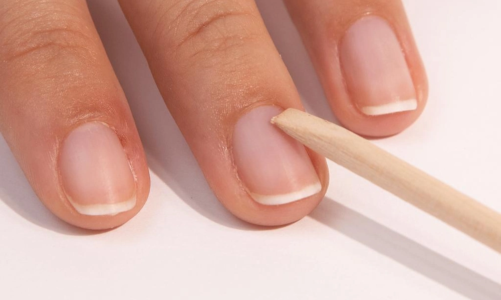 Using a wooden cuticle pusher for natural nail prep before applying gel x nails
