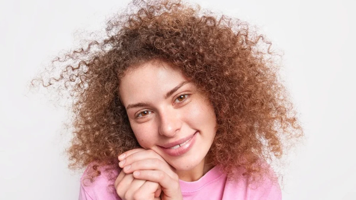 a girl with brown curly hairs