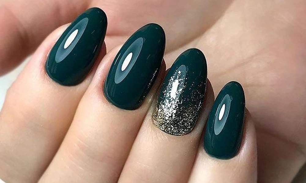 Glossy forest green Christmas nails paired with a sparkling gold glitter accent nail