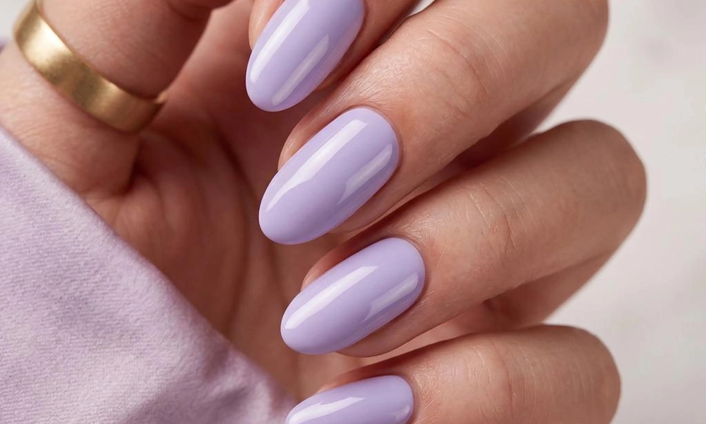 Smooth glossy lavender purple gel polish styled on graceful oval-shaped nails