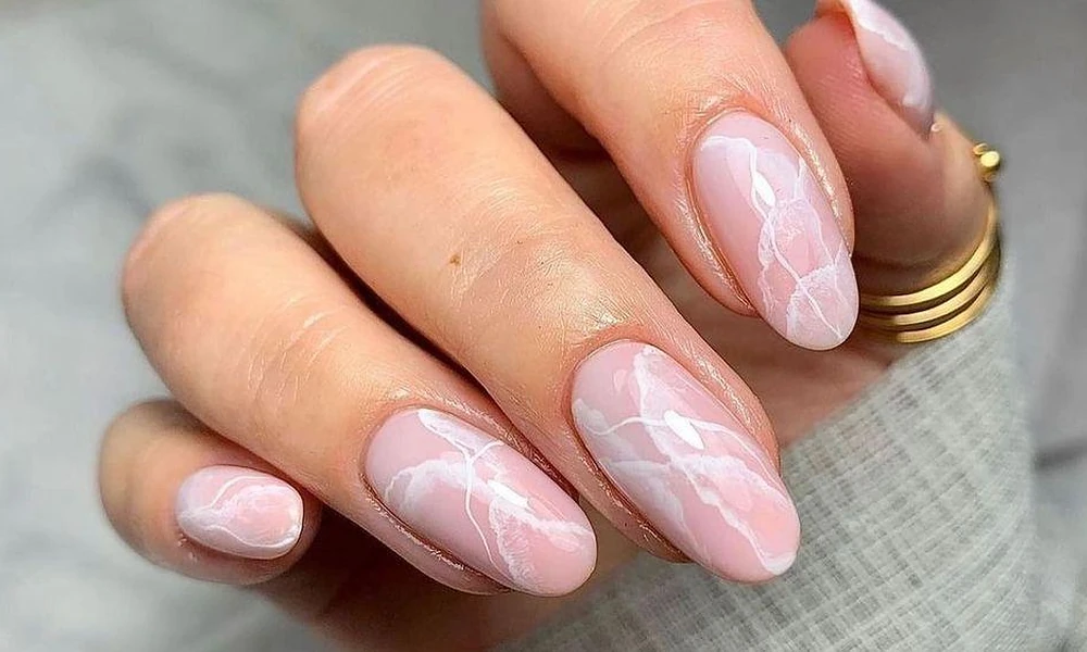 Soft blush pink background styled with realistic swirling white quartz marble veining-Cute Nail Ideas