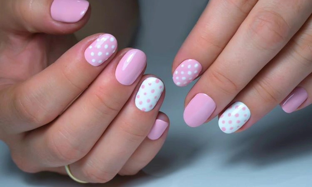 Glossy pink polish alternating with white accent tips decorated with neat pink polka dots