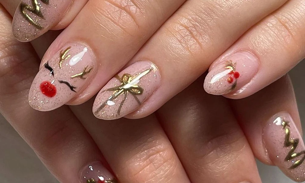 Playful reindeer Christmas nail art featuring cute faces and metallic gold holiday bows