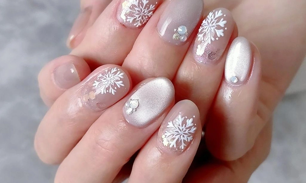 Shimmering winter snowflake Christmas nails enhanced with tiny sparkling rhinestones