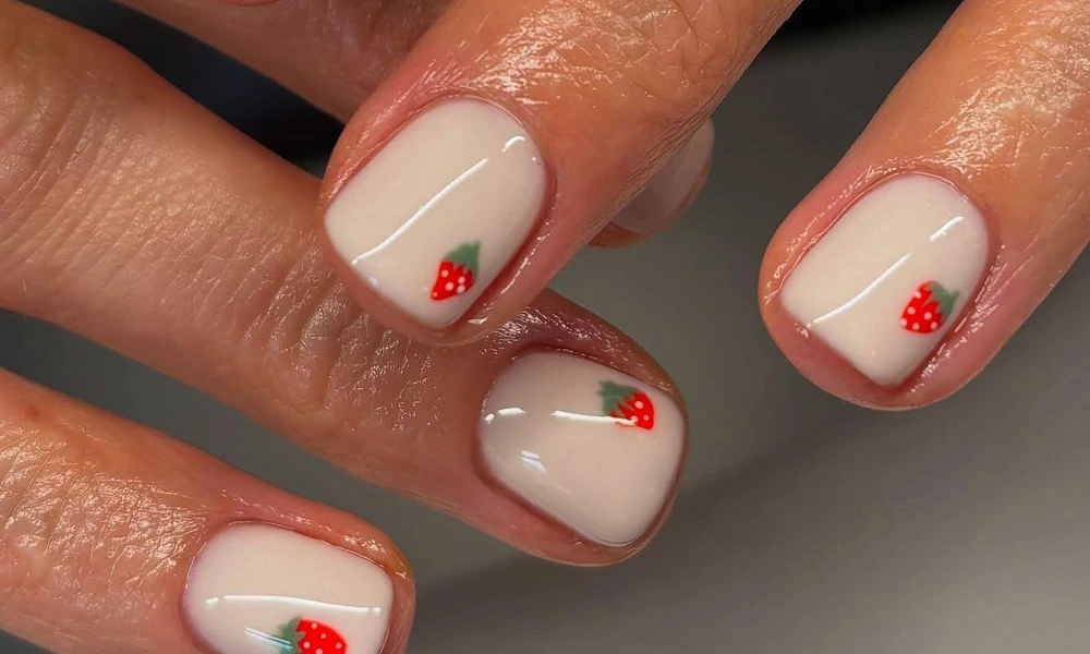 Creamy white base polish decorated with tiny hand-painted red strawberries on short square tips-Cute Nail Ideas