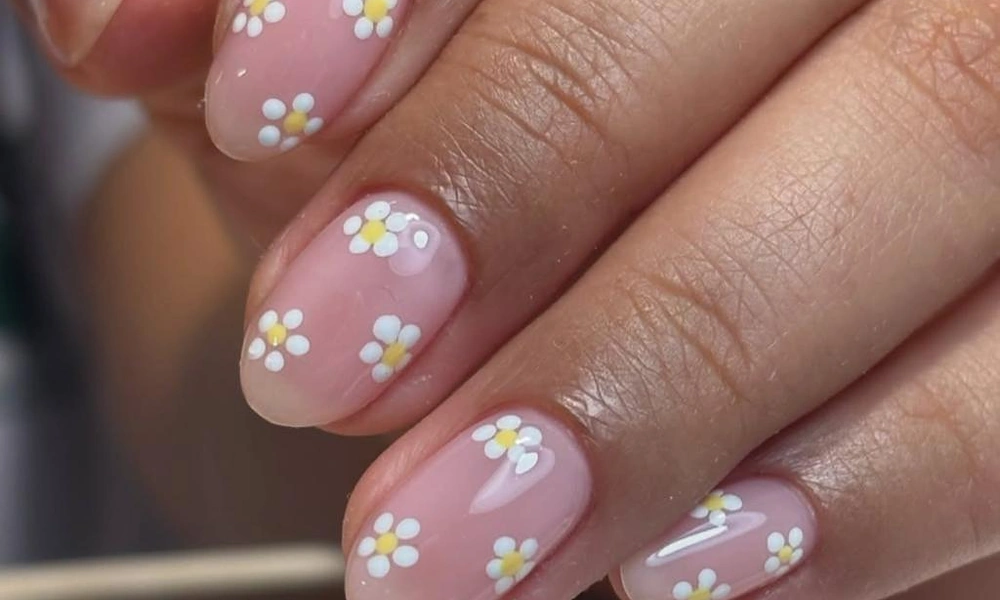 Translucent blush polish decorated with miniature hand-painted white and yellow daisies